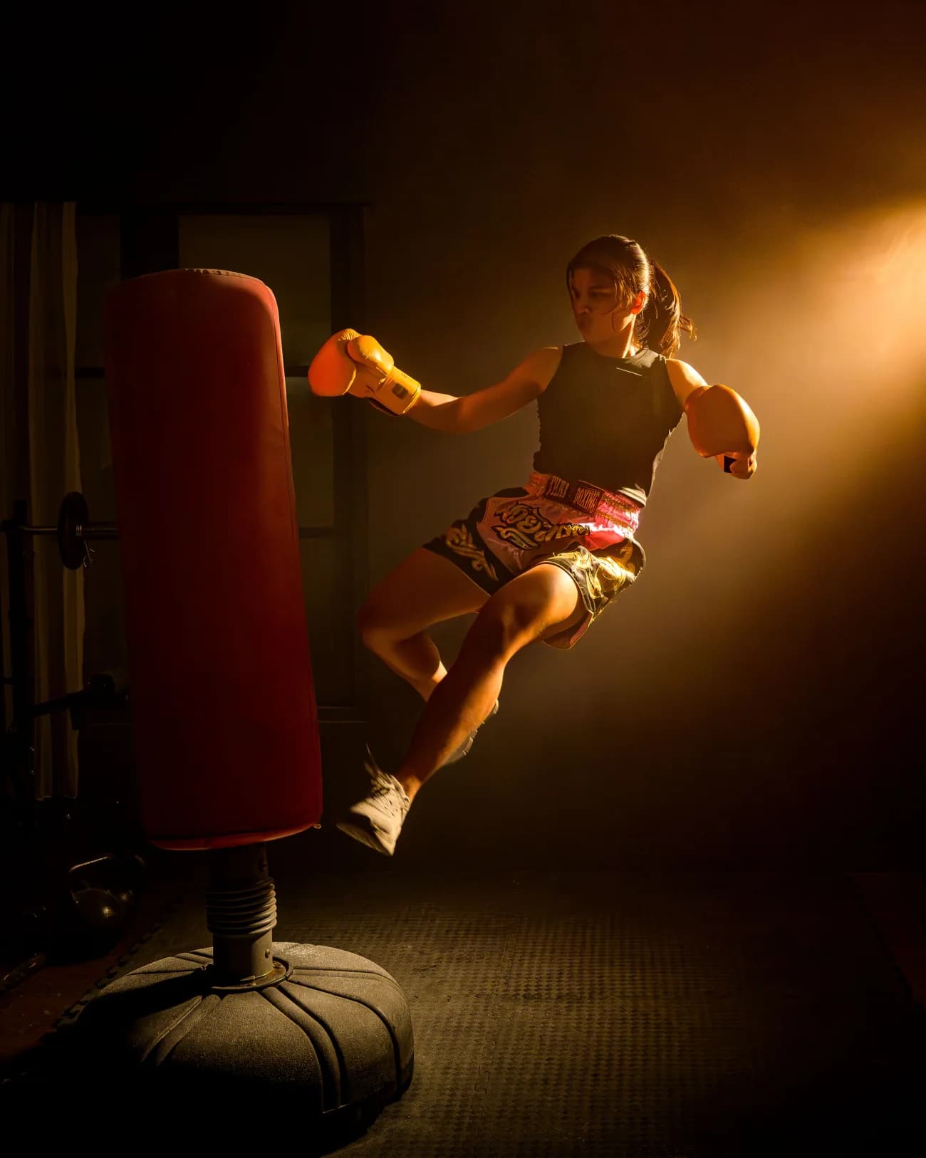 Kum torbasına tekme atan kadın kick boks sporcusu